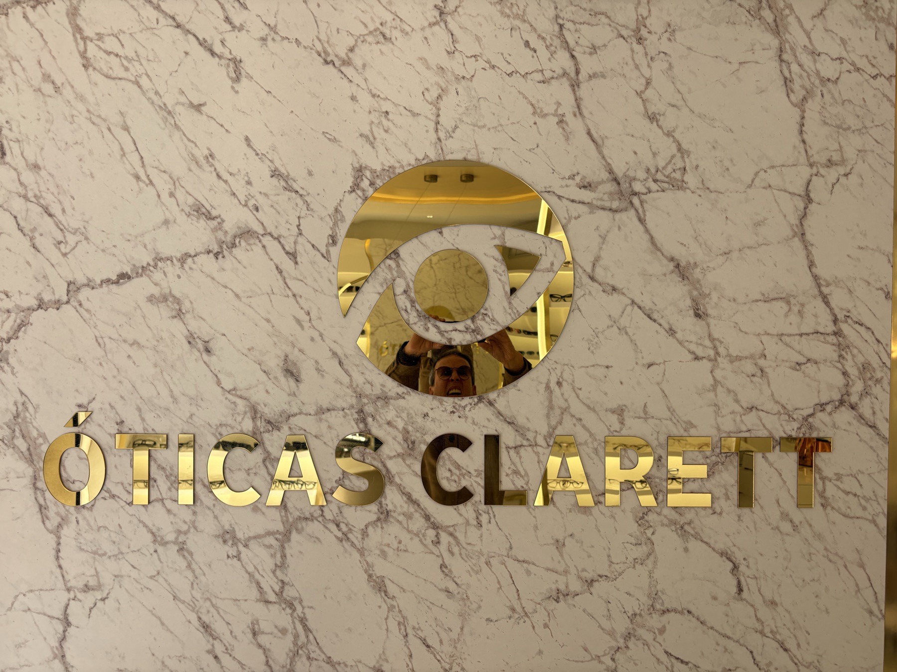 Óticas Clarett — placa da loja em mármore